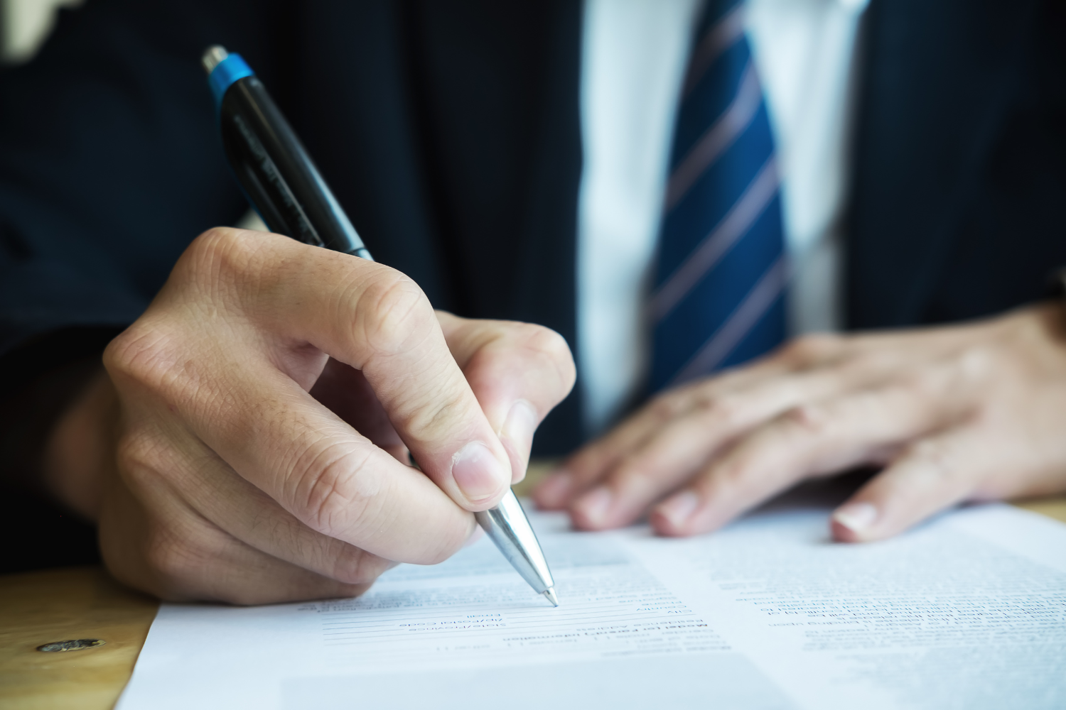 A business professional signing a document.