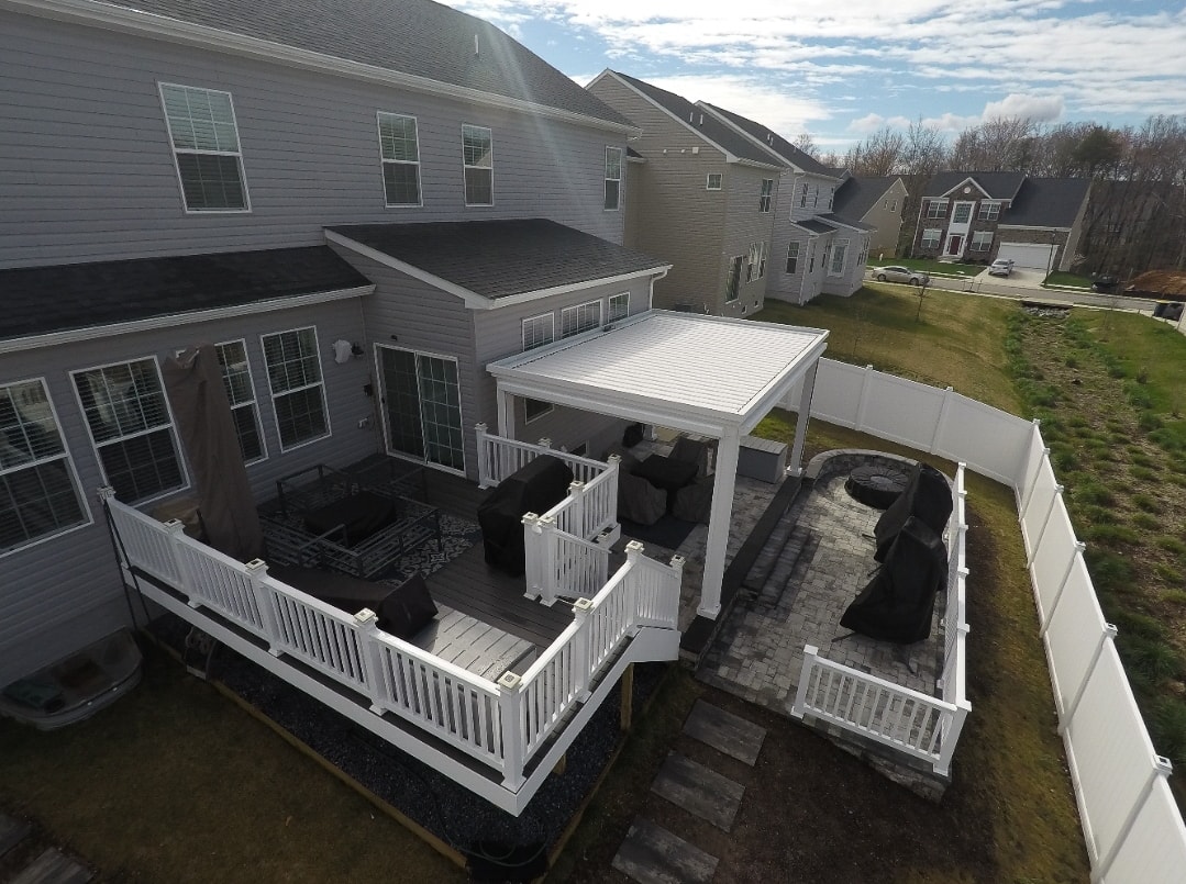 Fire pit installed in an outdoor living space next to pergola.