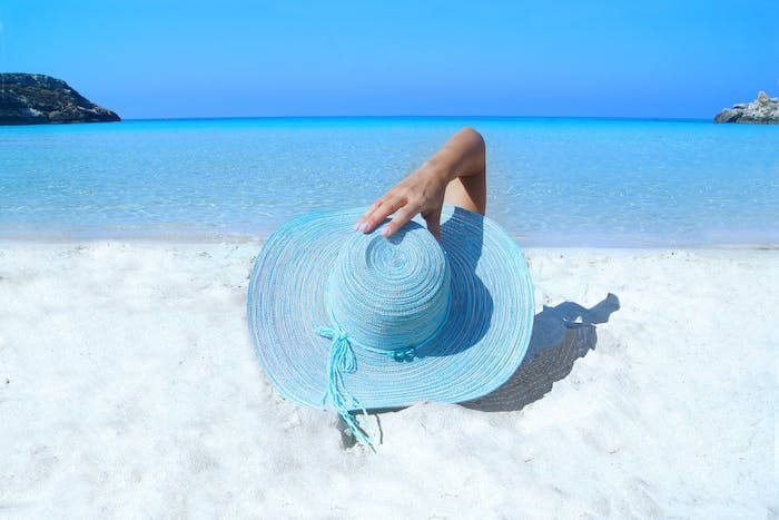 Woman relaxing on beach by rental property