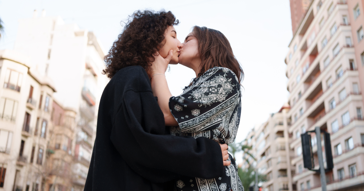 Image of a lesbian couple holding each other while walking through the bustling streets of New York City. Their connected hands symbolize the vital role of communication and mutual understanding in maintaining and strengthening their relationship within the LGBTQ+ community.