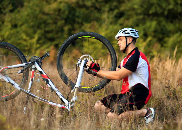 A mountain biker performing basic maintenance and repairs on their bike