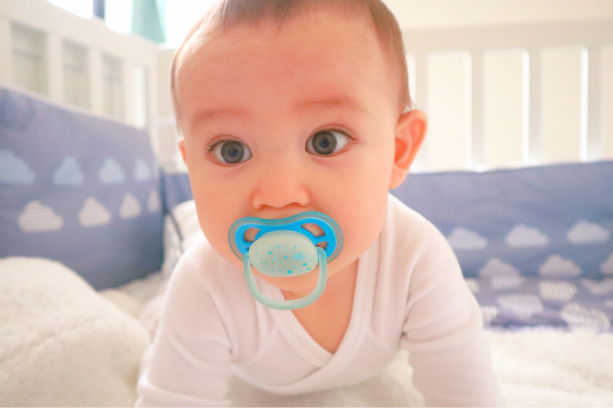 Newborn with binkie and pacifier in mouth