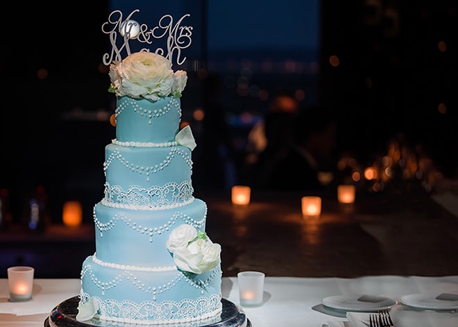 A creative wedding cake topper featuring a couple, surrounded by floral decorations.