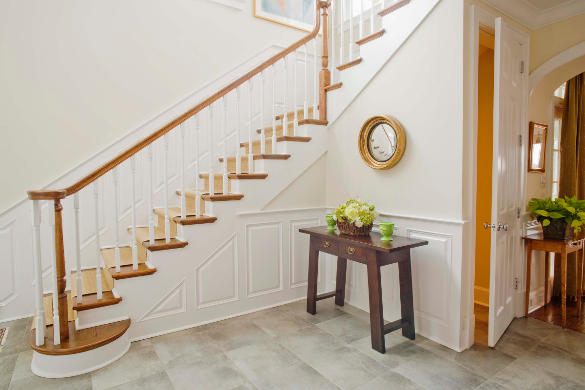 An oversized round mirror reflecting light in a stylish entryway.