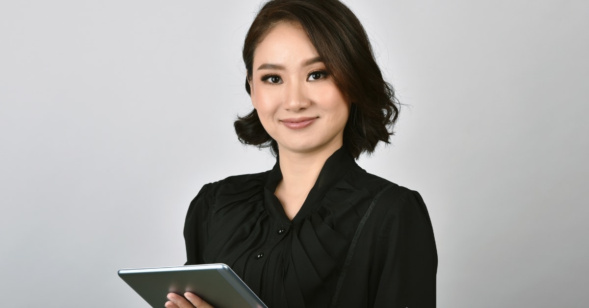 Professional woman holding a tablet, smiling, and ready to discuss business expense categories.