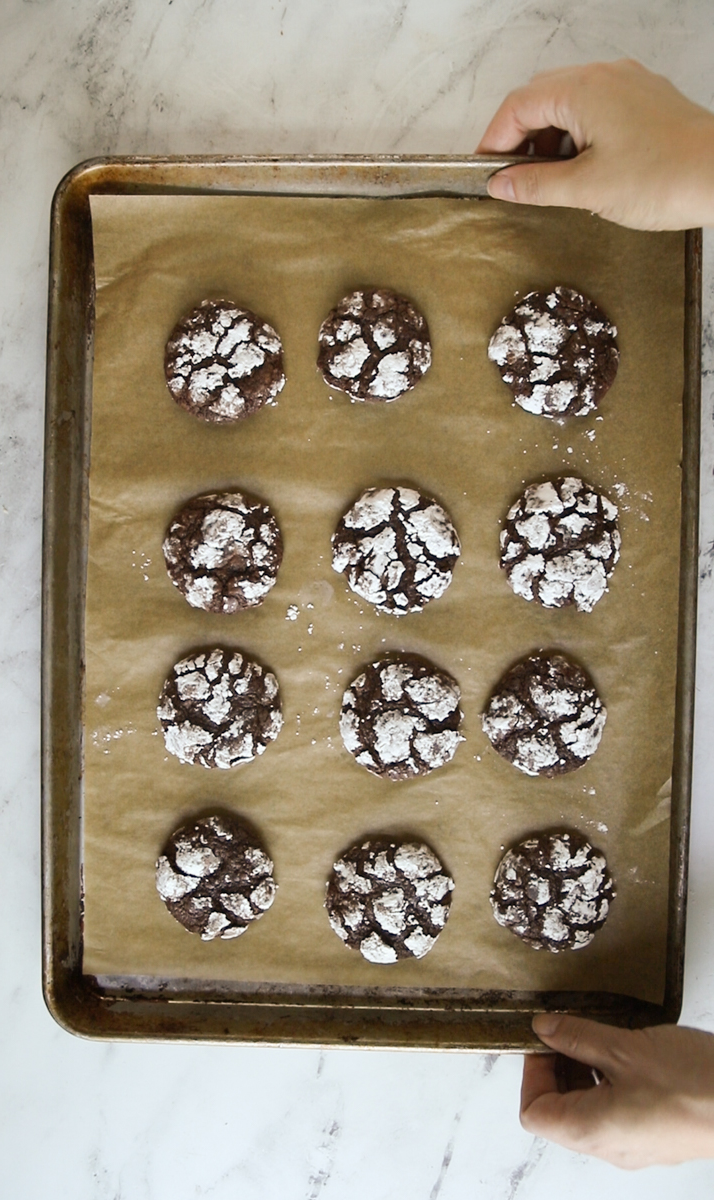 12 baked double chocolate crinkles on a cookie sheet