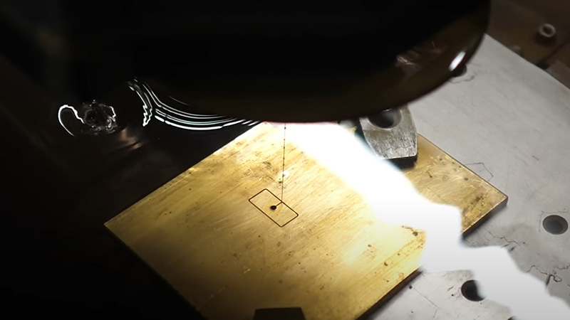 Elettroerosione a filo su una piastra di ottone immersa in una soluzione dielettrica