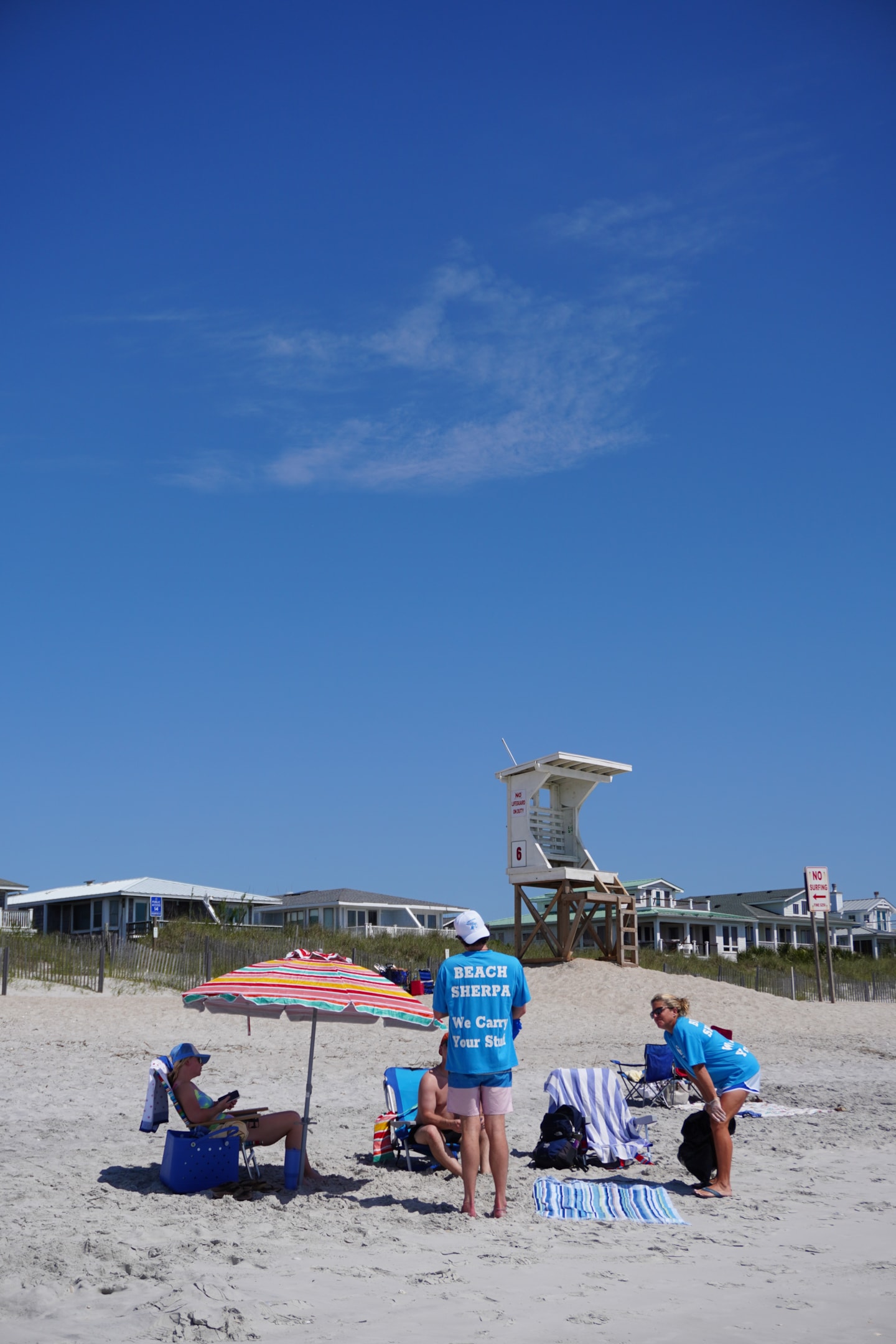 a couple of beach sherpas helping out beachgoers with their setup on wrightsville beach