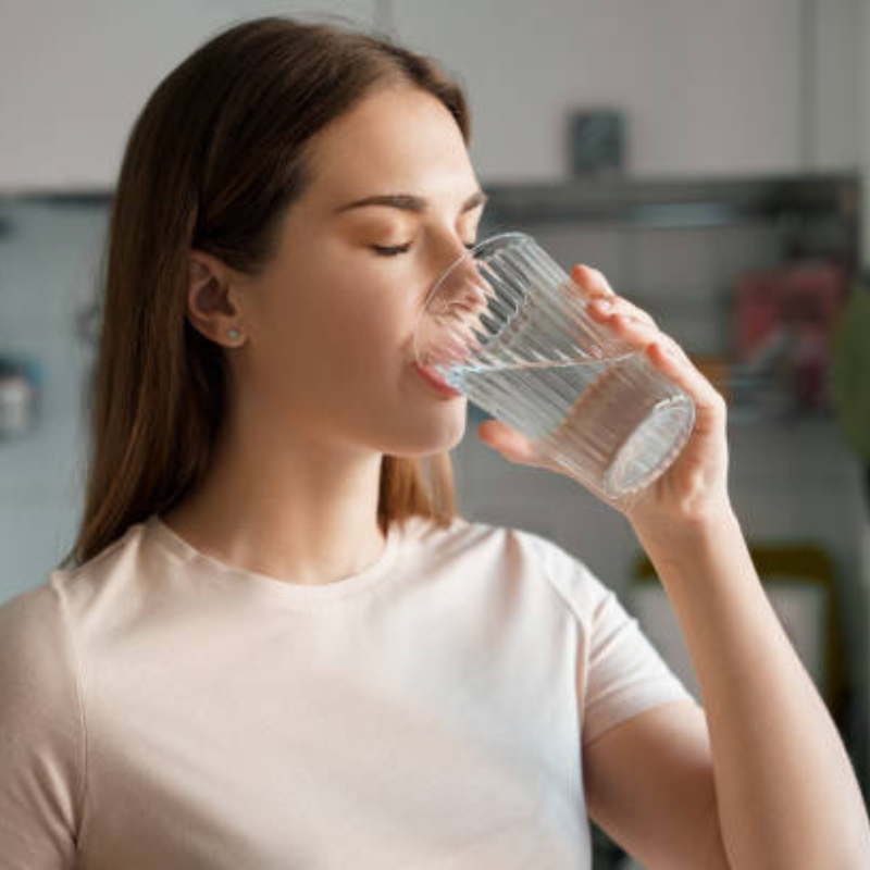 Image showing a person drinking water to manage dry mouth from Invisalign braces.