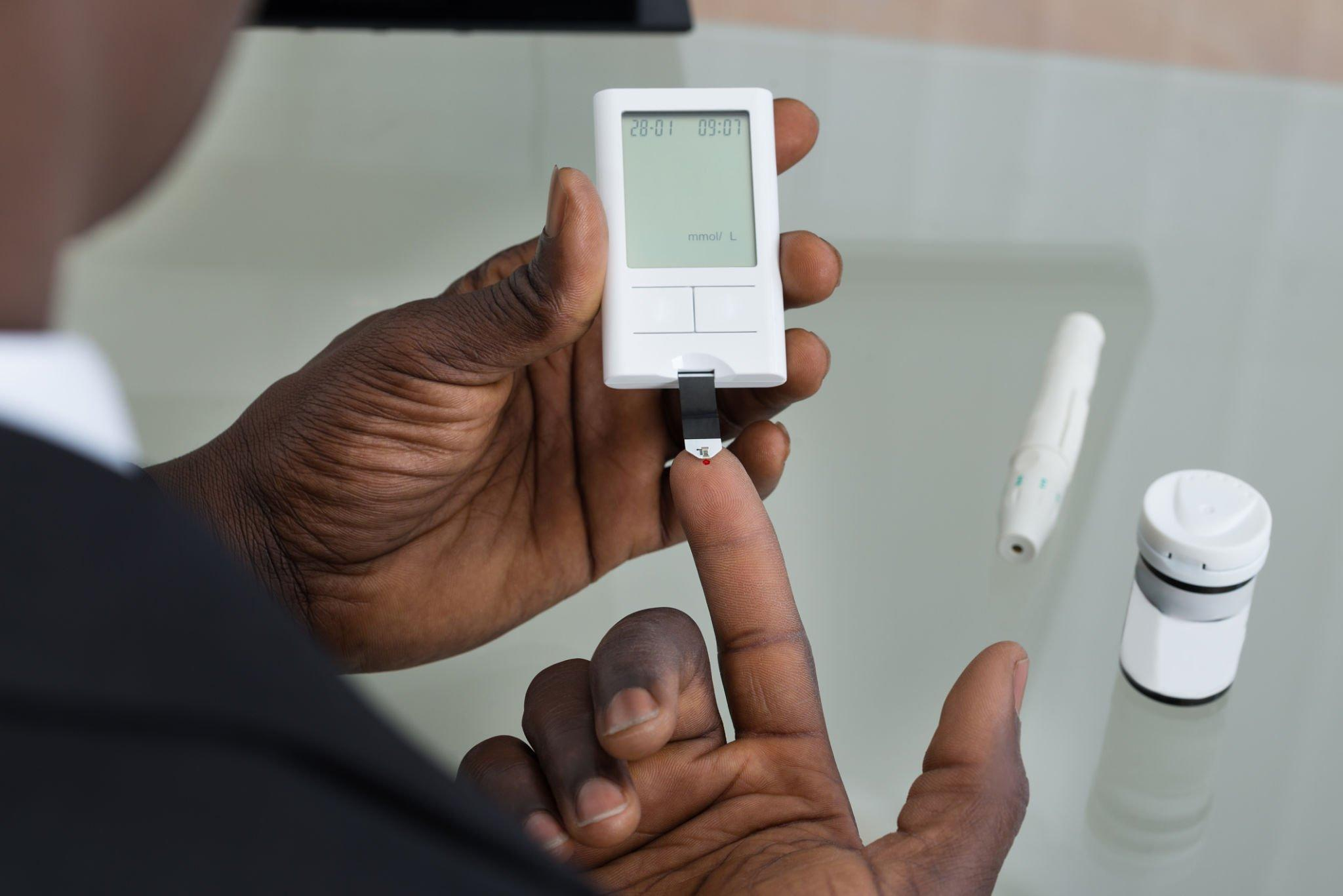 A man performing blood test or multiple blood tests by pricking his finger and using test strip to measure blood sugar levels.