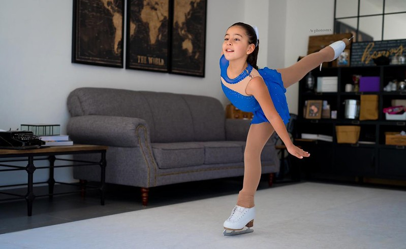 girl figure skating in her living room