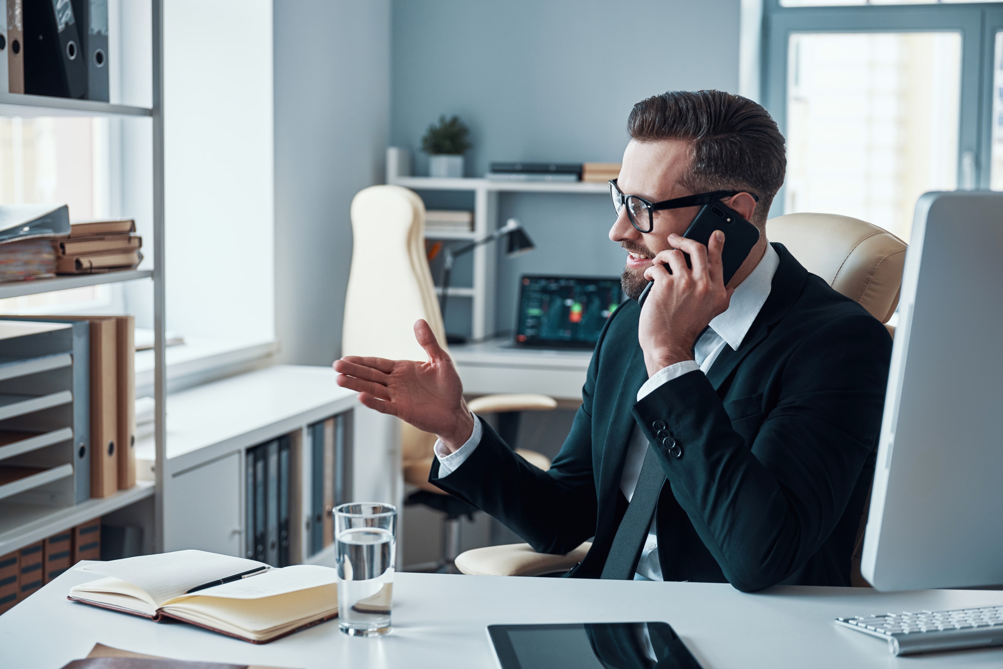 Businessman speaking on the phone at his desk.