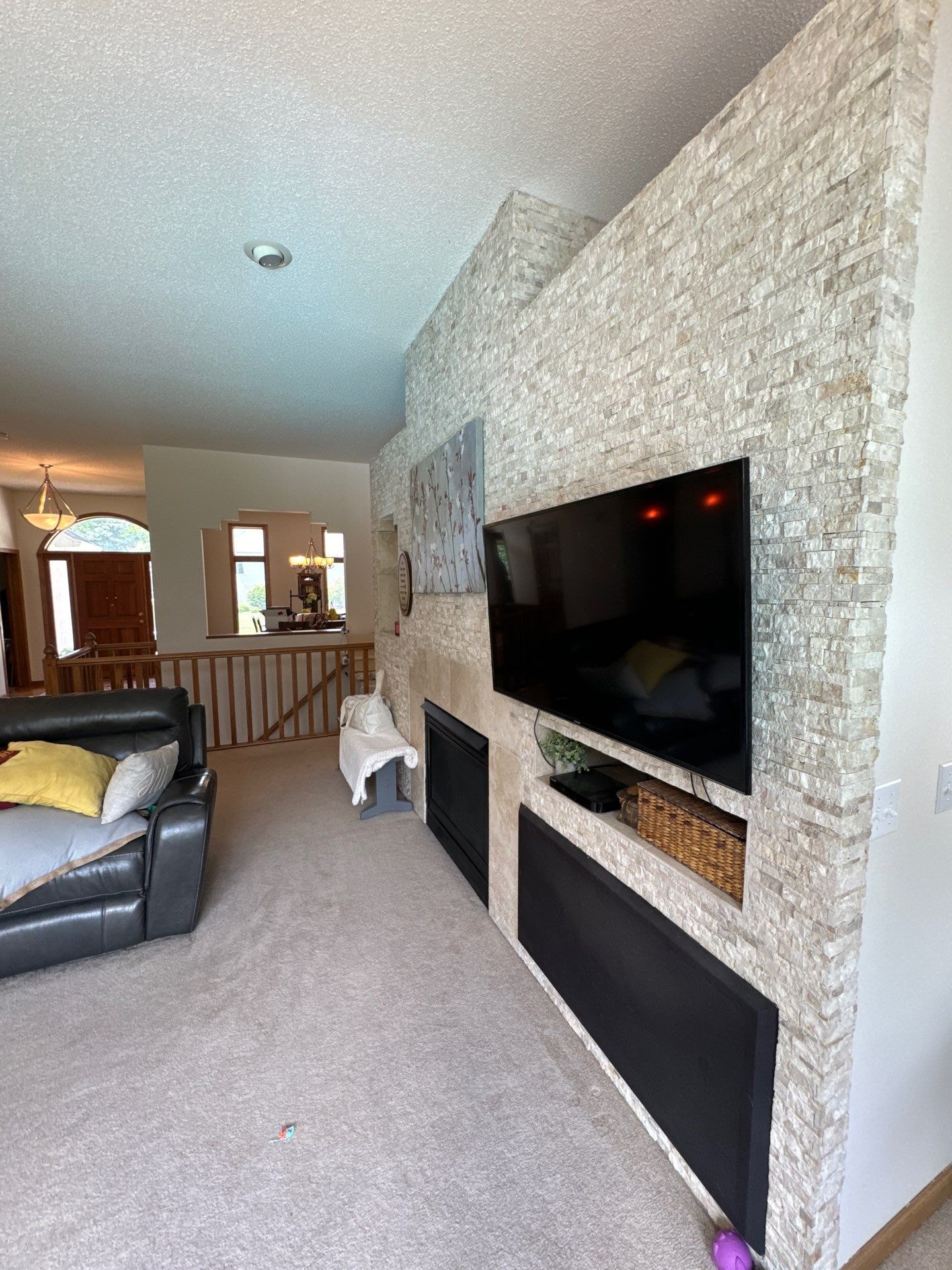 living room color ideas: a spacious living room featuring a light, neutral gray carpet and a textured off-white stone accent wall