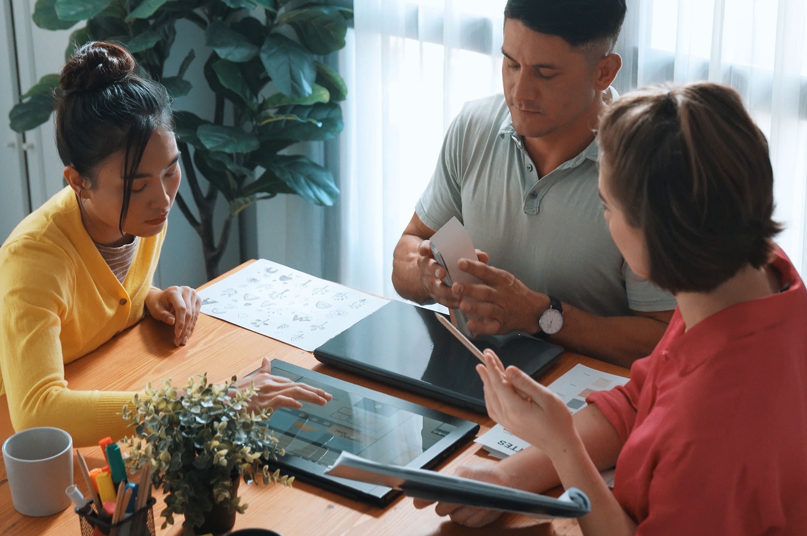 Family discussing financial planning with documents and laptop.