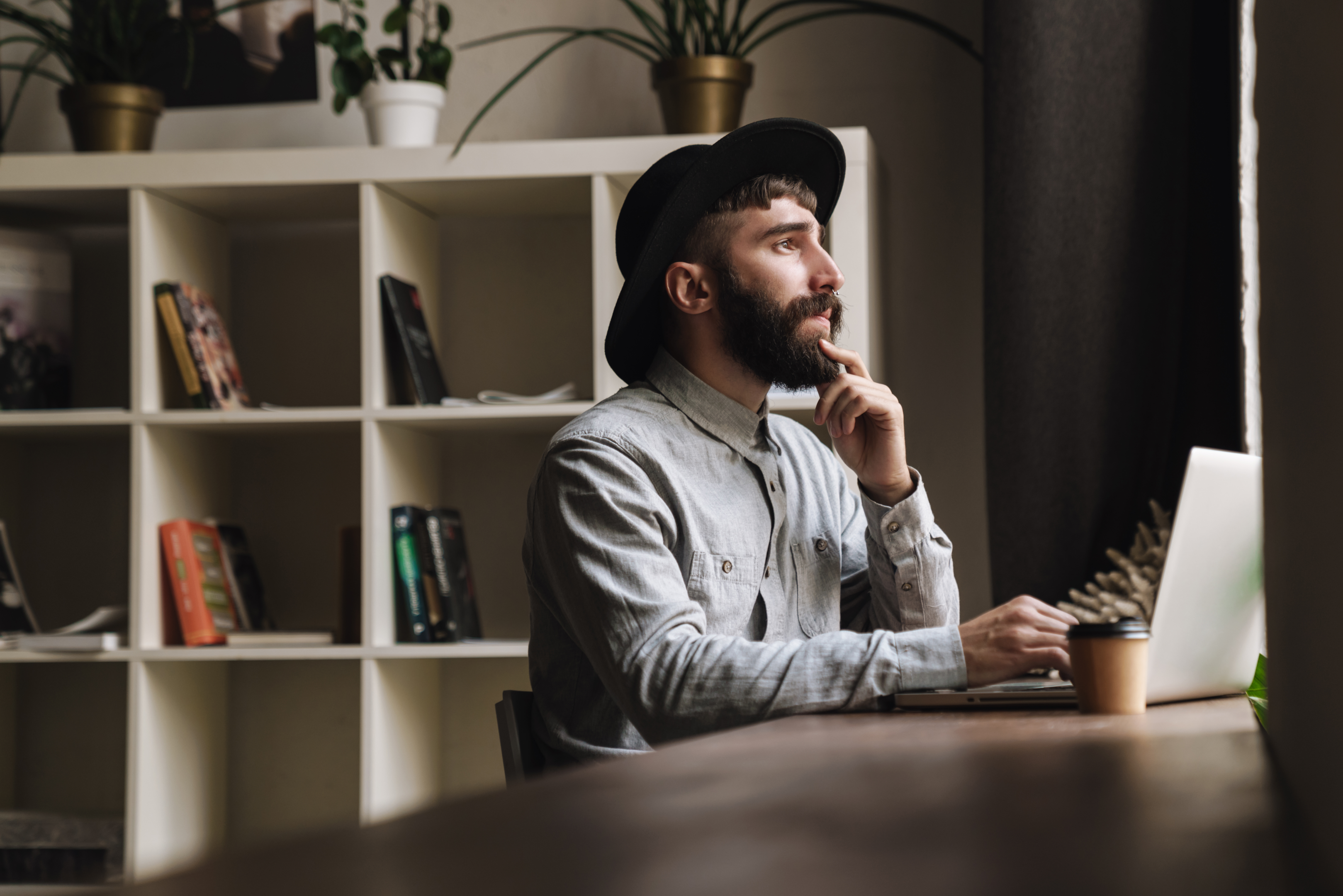 Man thinking using laptop