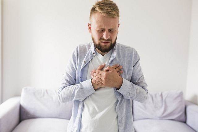An image of a man with heartburn holding his chest. 