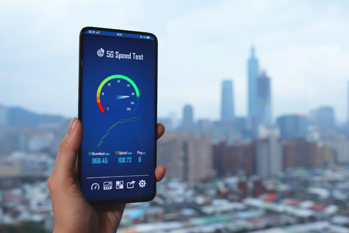 5G internet speed test on smartphone screen with city skyline in background