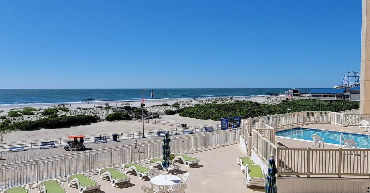 Oceanfront pool deck at 1900 Boardwalk in North Wildwood NJ with lounge chairs overlooking the beach, dunes, and Wildwood Boardwalk.