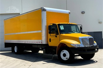 A box truck parked in front of a loading dock with a dock height measurement visible