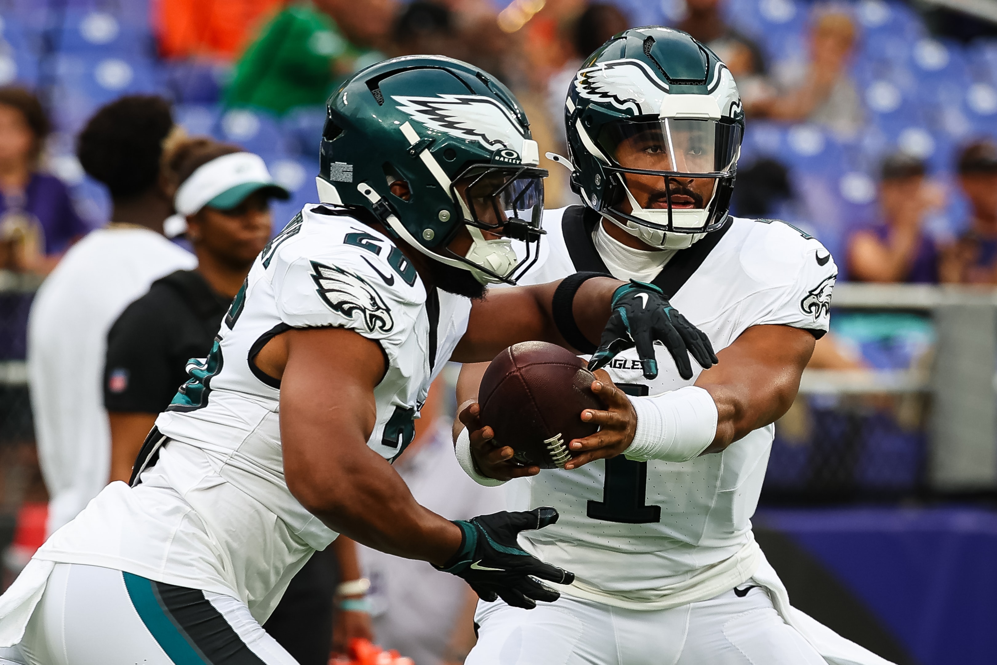 Jalen Hurts of the Philadelphia Eagles hands the ball off to Saquon Barkley in a preseason game against the Baltimore Ravens.