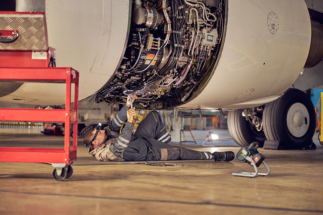 An aviation mechanic performing maintenance on an aircraft.