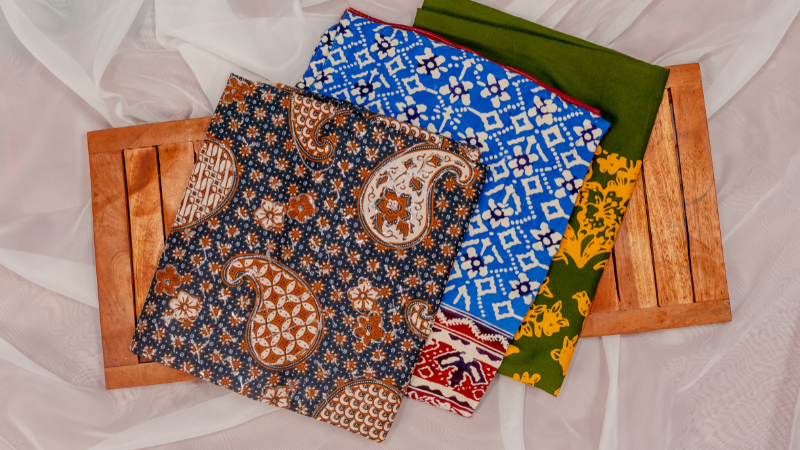 Three different types of batik fabric on a wooden tray