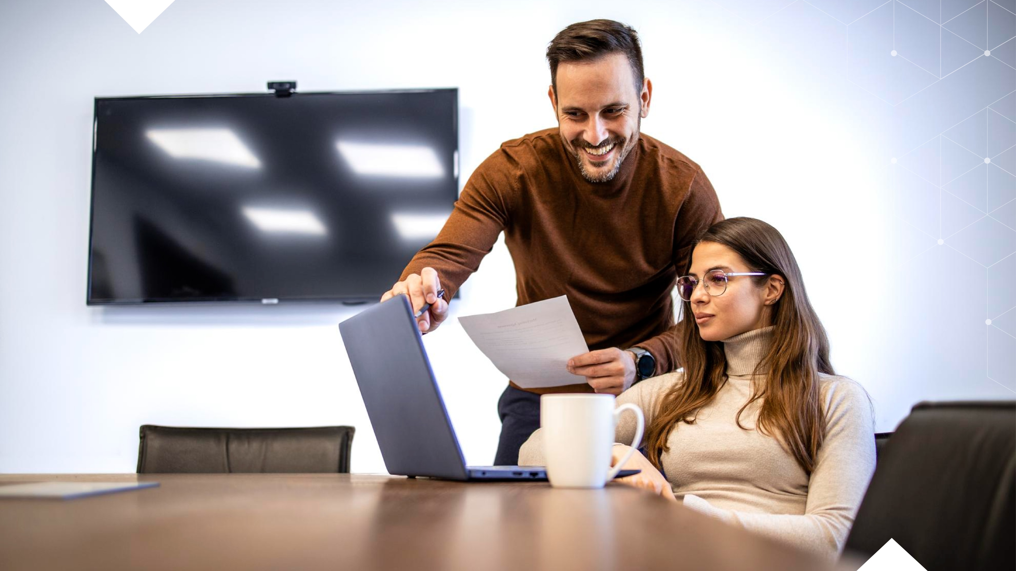Two people looking at a laptop screen and pointing to which telecom services and telecom expenses each site uses.