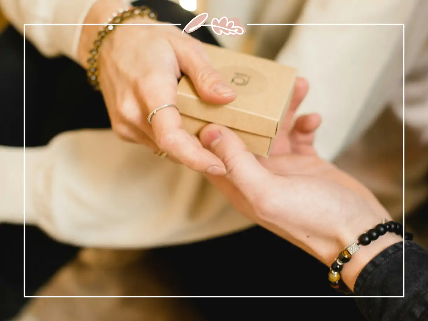 Hands exchanging a small brown gift box - fabulous flowers and gifts