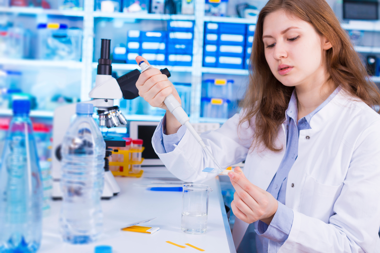 Technician in lab coat testing supplements in a laboratory setting.