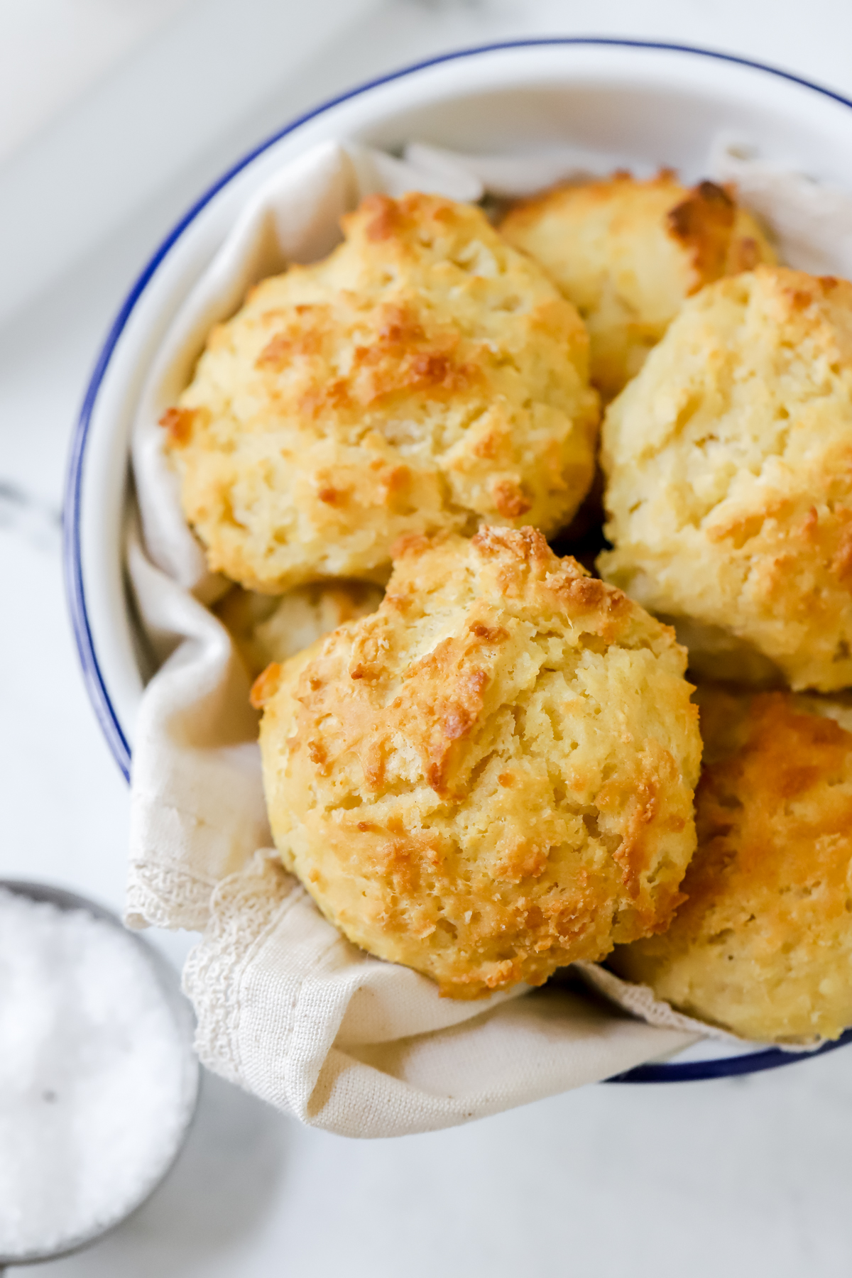 Linen lined bowl filled with buttermilk drop biscuits