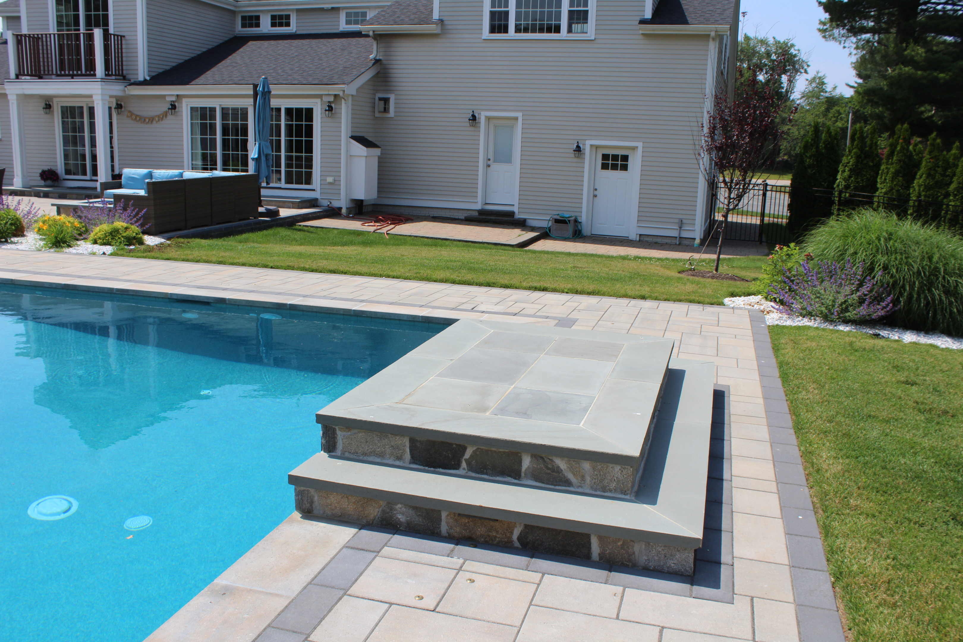 Modern pool deck design with vibrant colors, textures, and water features
