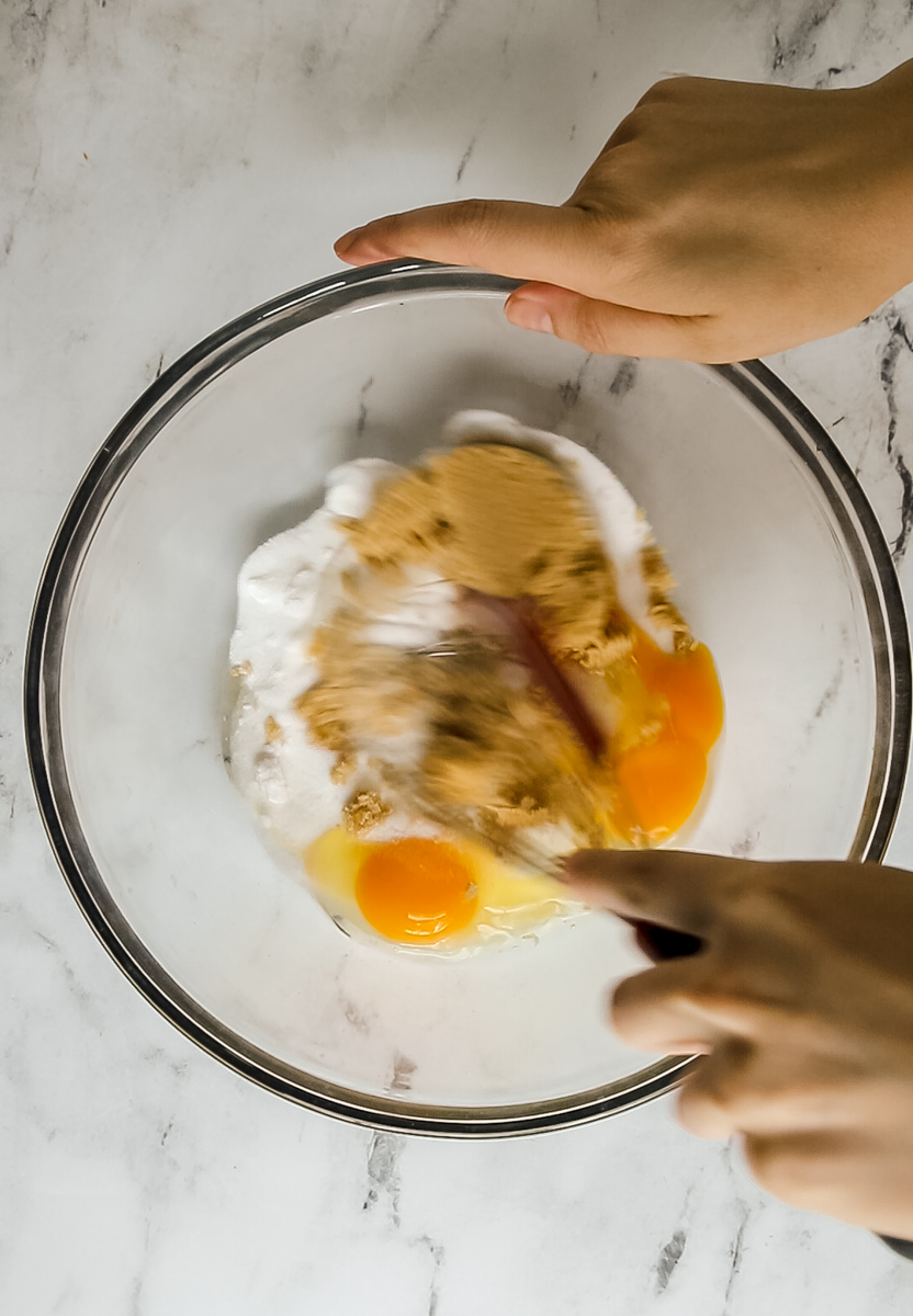sugar and eggs being whisked together in a large bowl