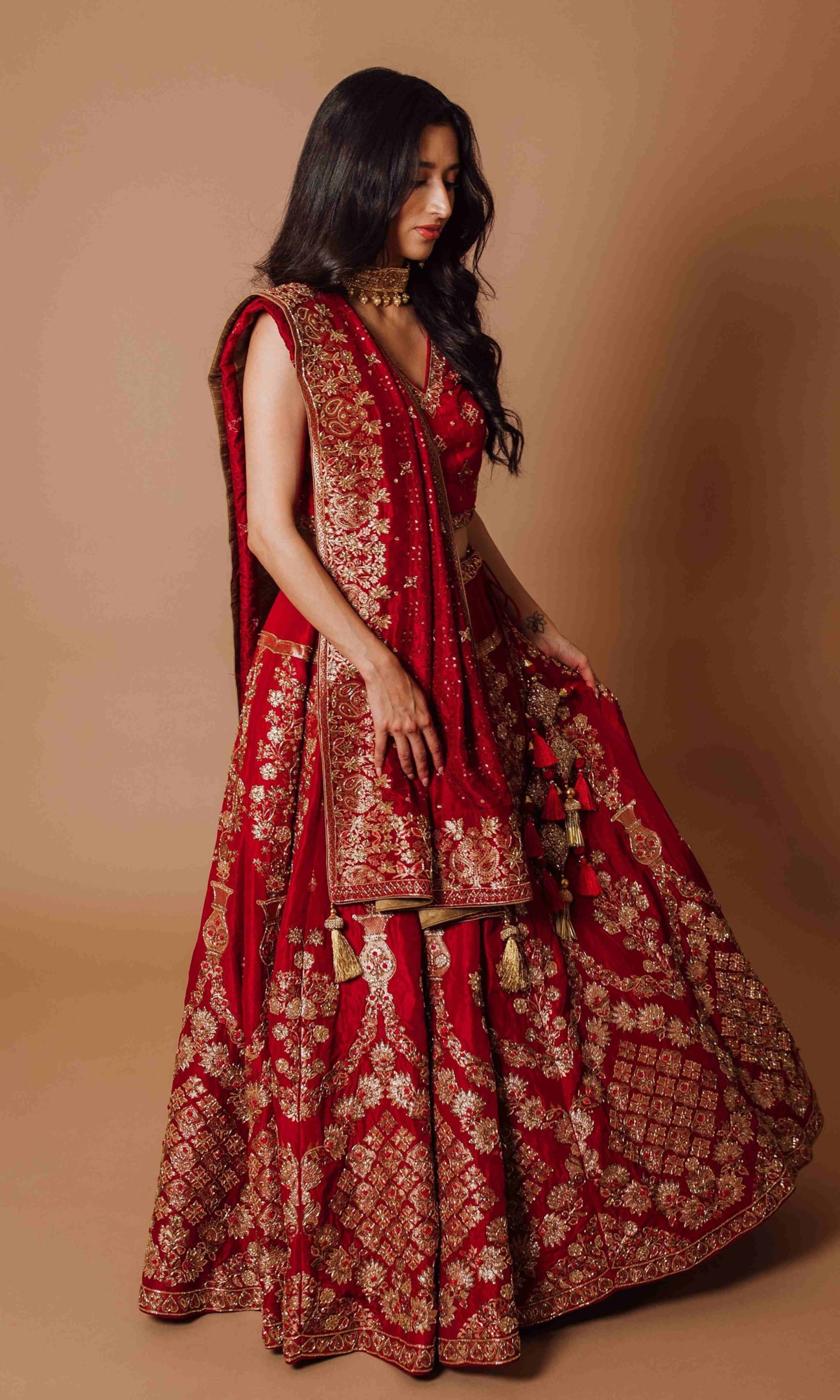 Traditional red bridal lehenga choli with intricate motifs.