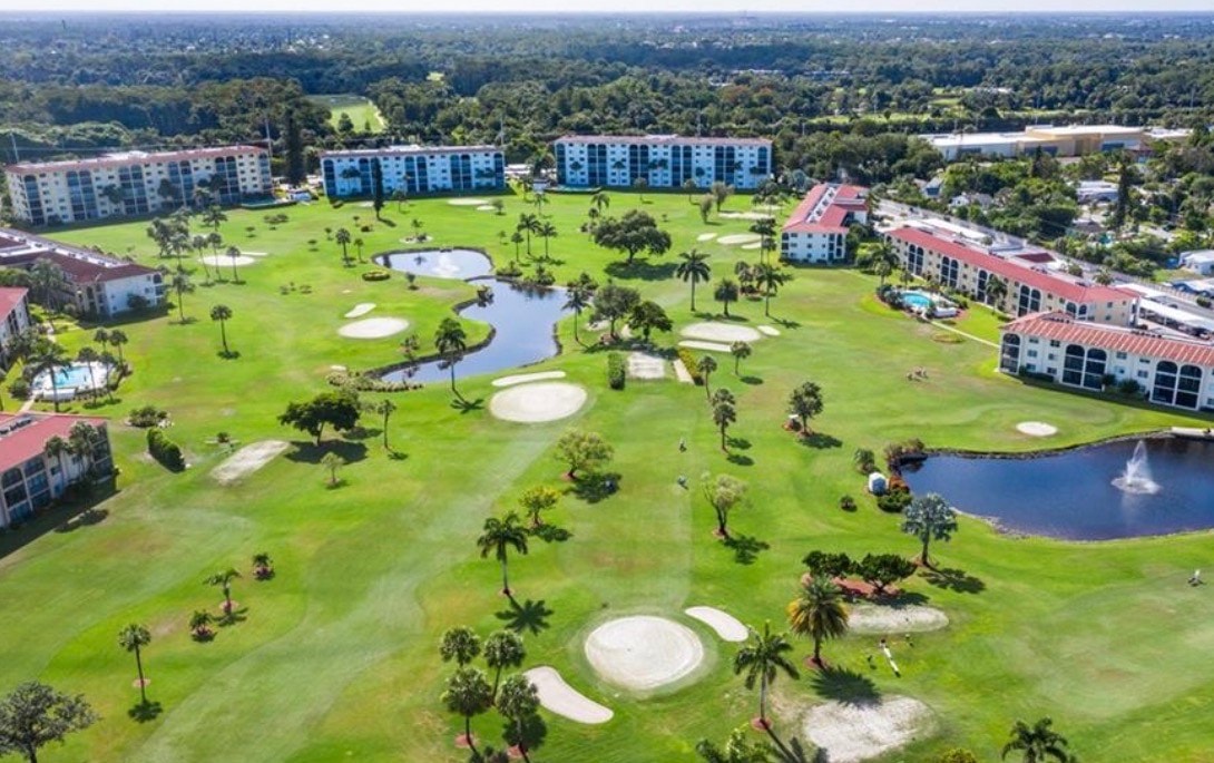 The image shows a community swimming pool area surrounded by lush tropical landscaping, featuring inviting lounge chairs for relaxation. This serene space exemplifies the exceptional community amenities that residents can enjoy at High Point Country Club, perfect for embracing a welcoming and active lifestyle.