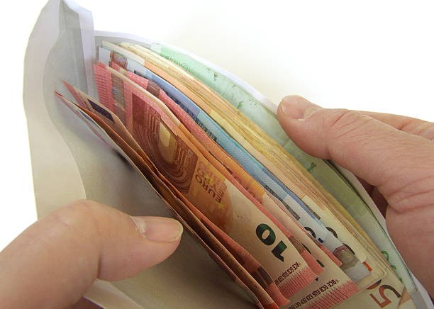 Euro paper bills in different denomination placed in an envelope.