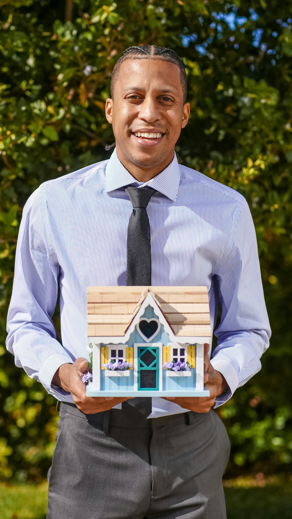 Real estate investor holds small model of home.