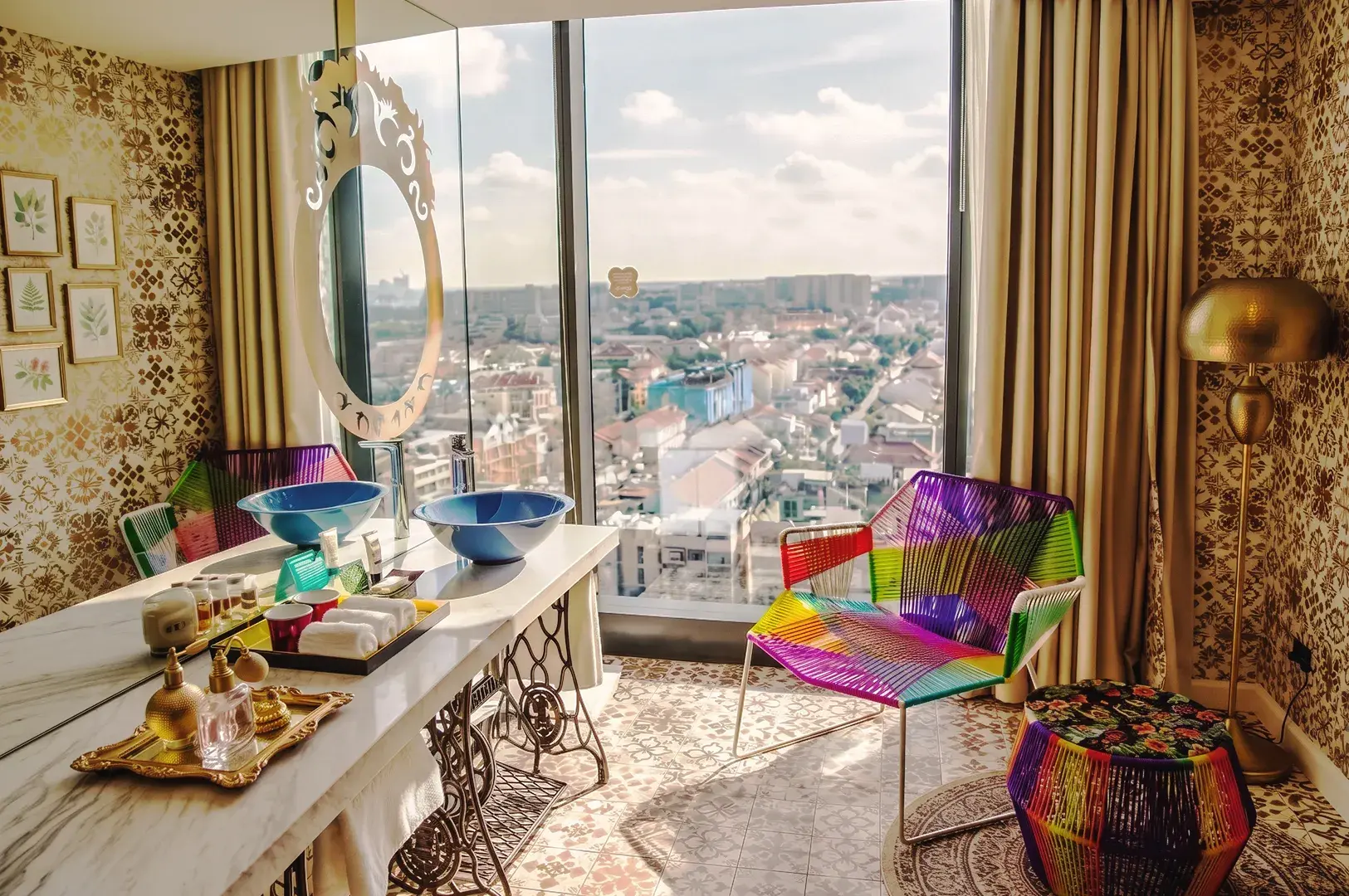 Artistic boutique hotel room in Singapore with colorful décor, marble vanity, and panoramic city skyline view.