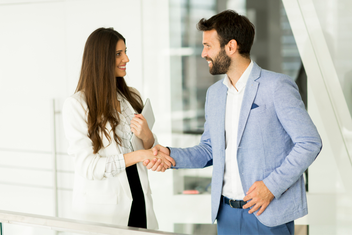 Buyer and seller shaking hands during small business sale meeting