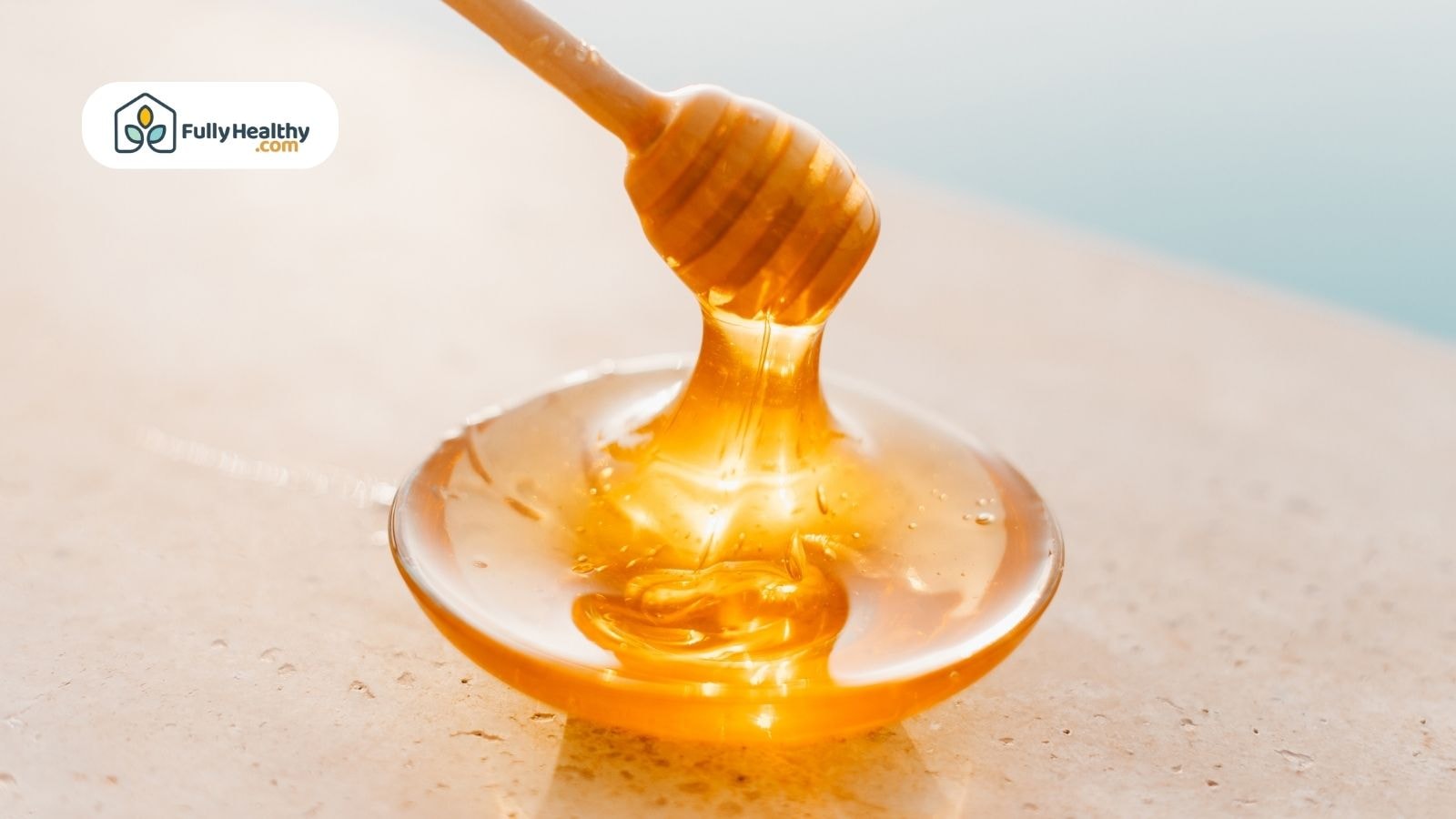 Golden honey dripping from dipper onto plate