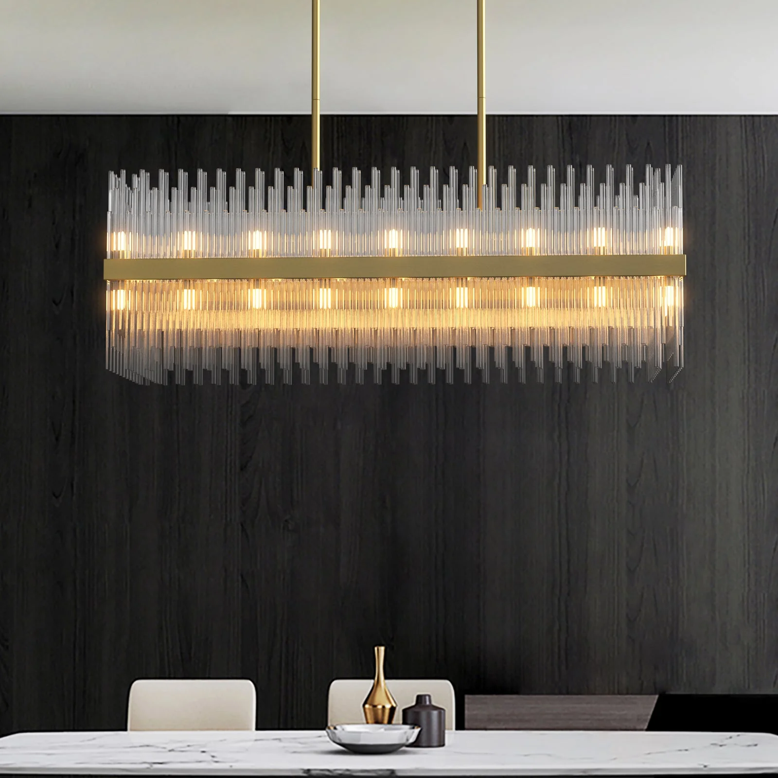 A modern tubular rectangular chandelier installed in a dining room casting a shimmering soft warm glow