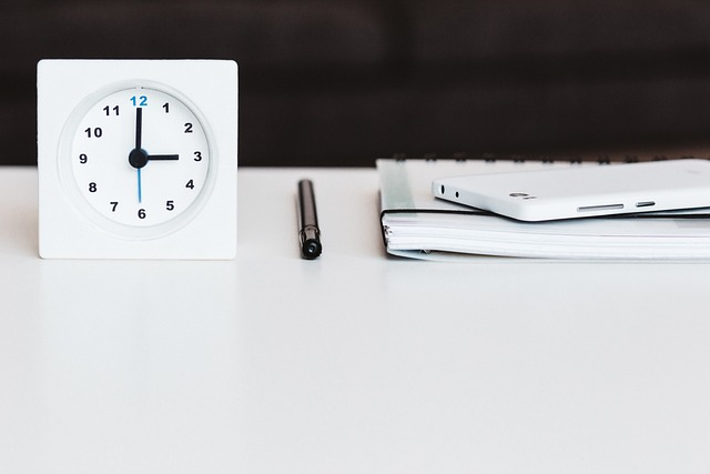 Clock next to schedule on white table