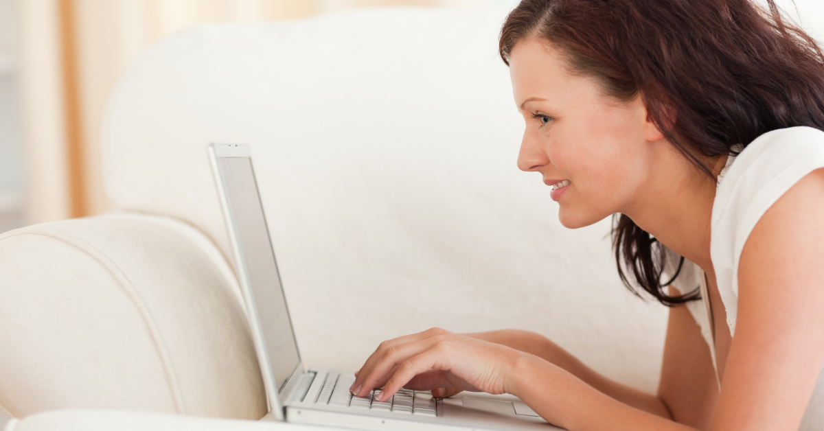 An OnlyFans creator laying on her bed using a laptop, searching the internet for “How many men are subscribed to OnlyFans in the US?” statistics and insights.
