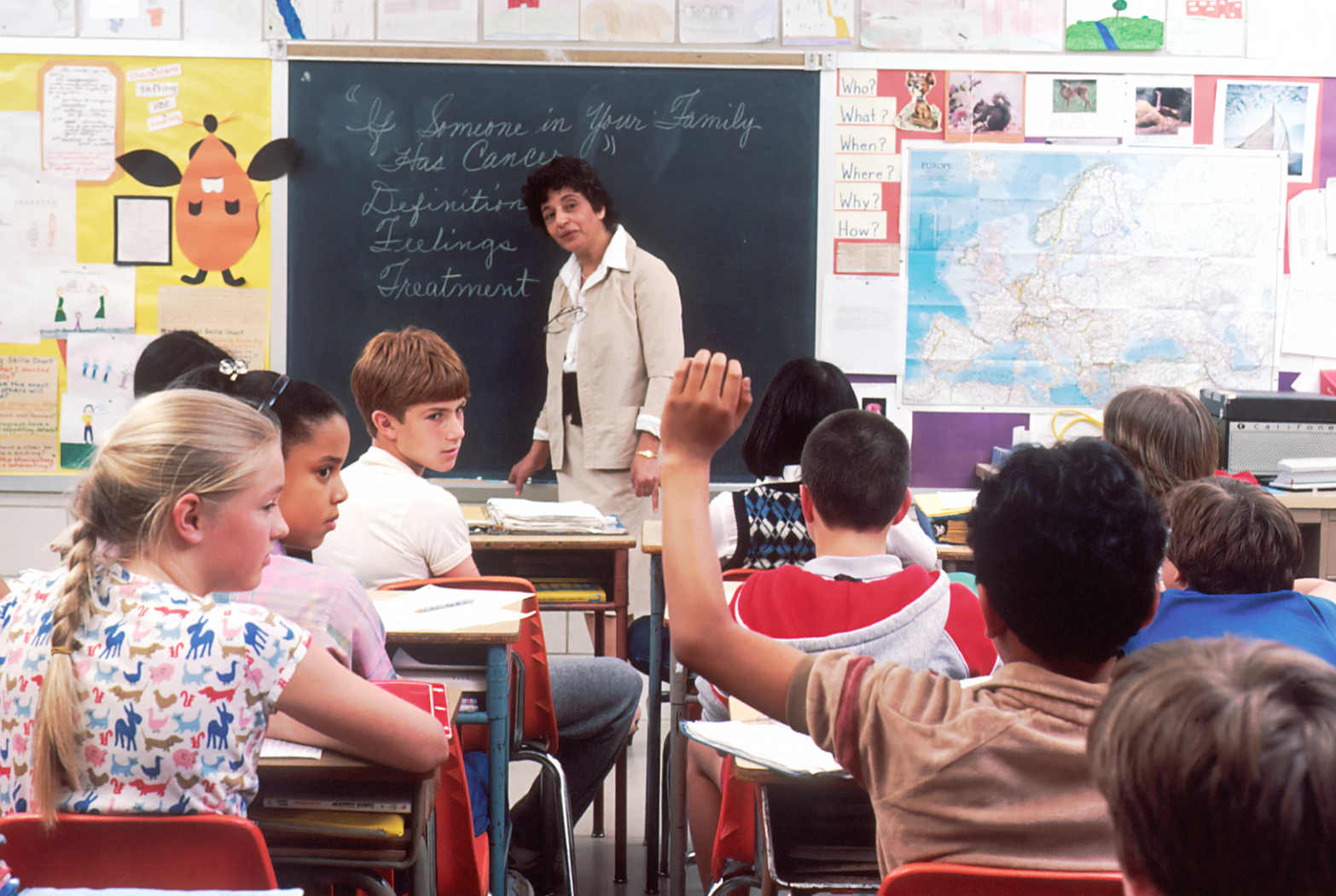 (Source: unsplash.com/@nci) School children having class with one raising his hand.