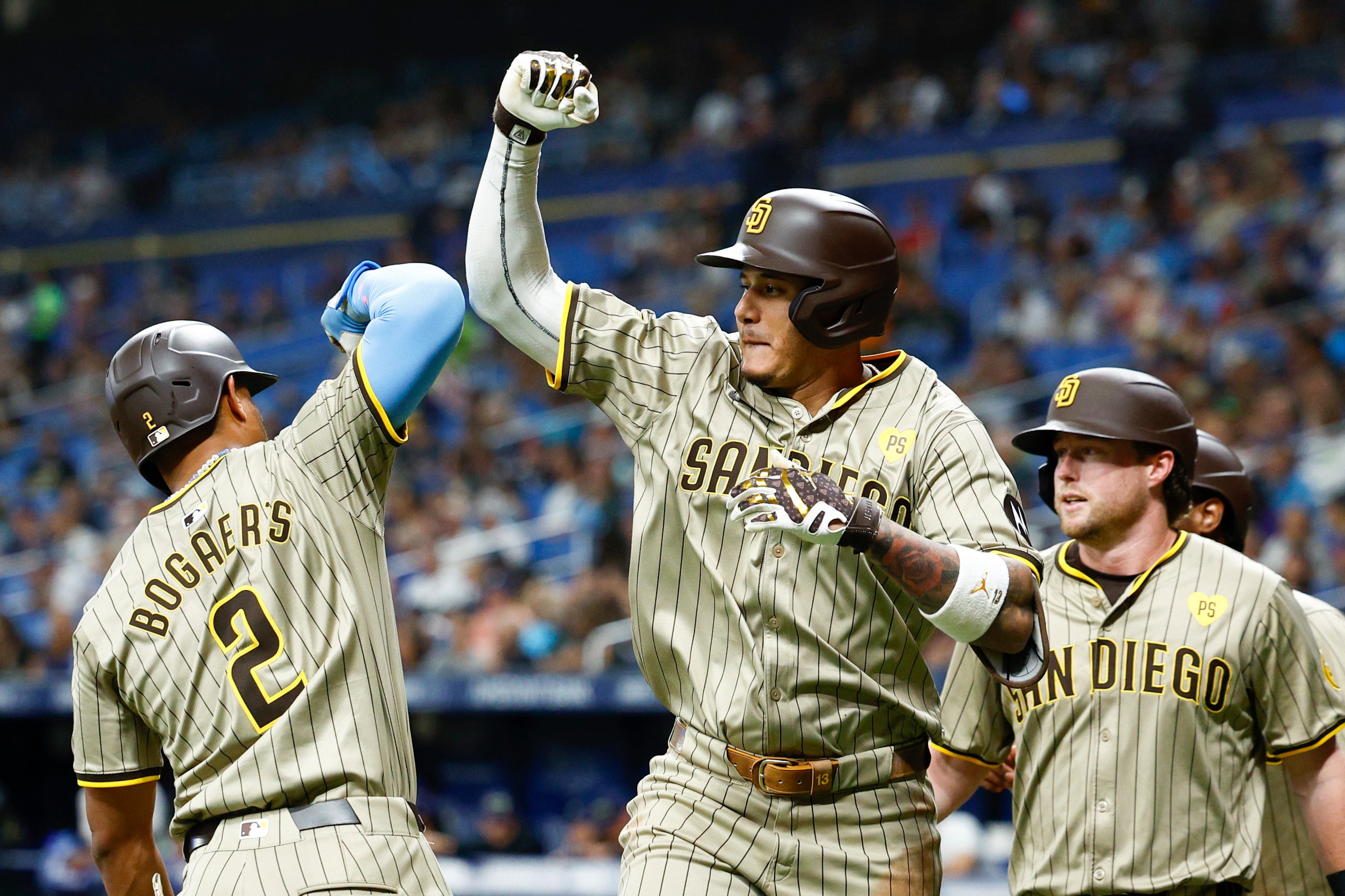 Manny Machado of the San Diego Padres reacts with Xander Bogaerts after hitting a three run home run against the Tampa Bay Rays at Tropicana Field on August 30, 2024.