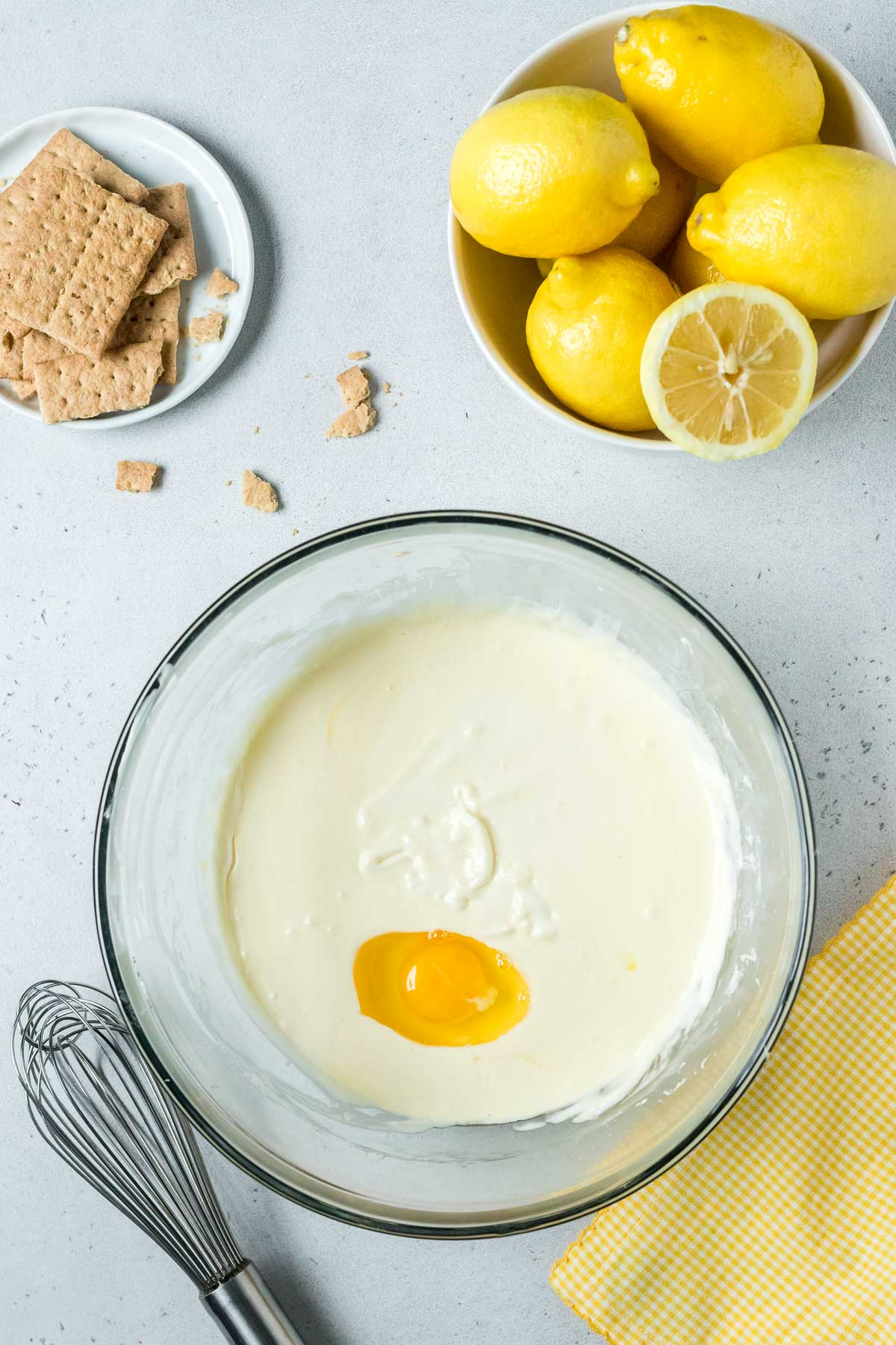 eggs and sour cream in bowl with lemon cheesecake batter