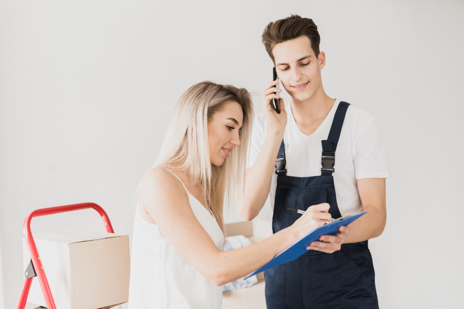 Customer receiving a package from a delivery worker while reviewing delivery paperwork