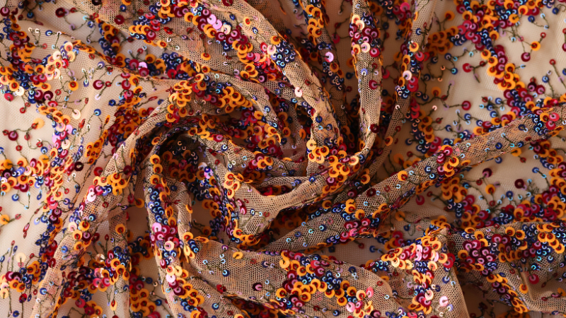 A close-up view of an orange and blue floral sheer fabric