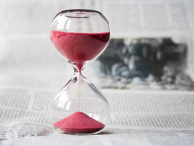 An image of an hourglass with red sand.
