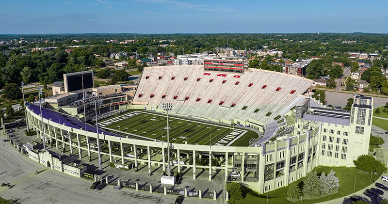 Aerial side-angle drone view of Indiana University Memorial Stadium, home of the Indiana Hoosiers, in Bloomington, Indiana.