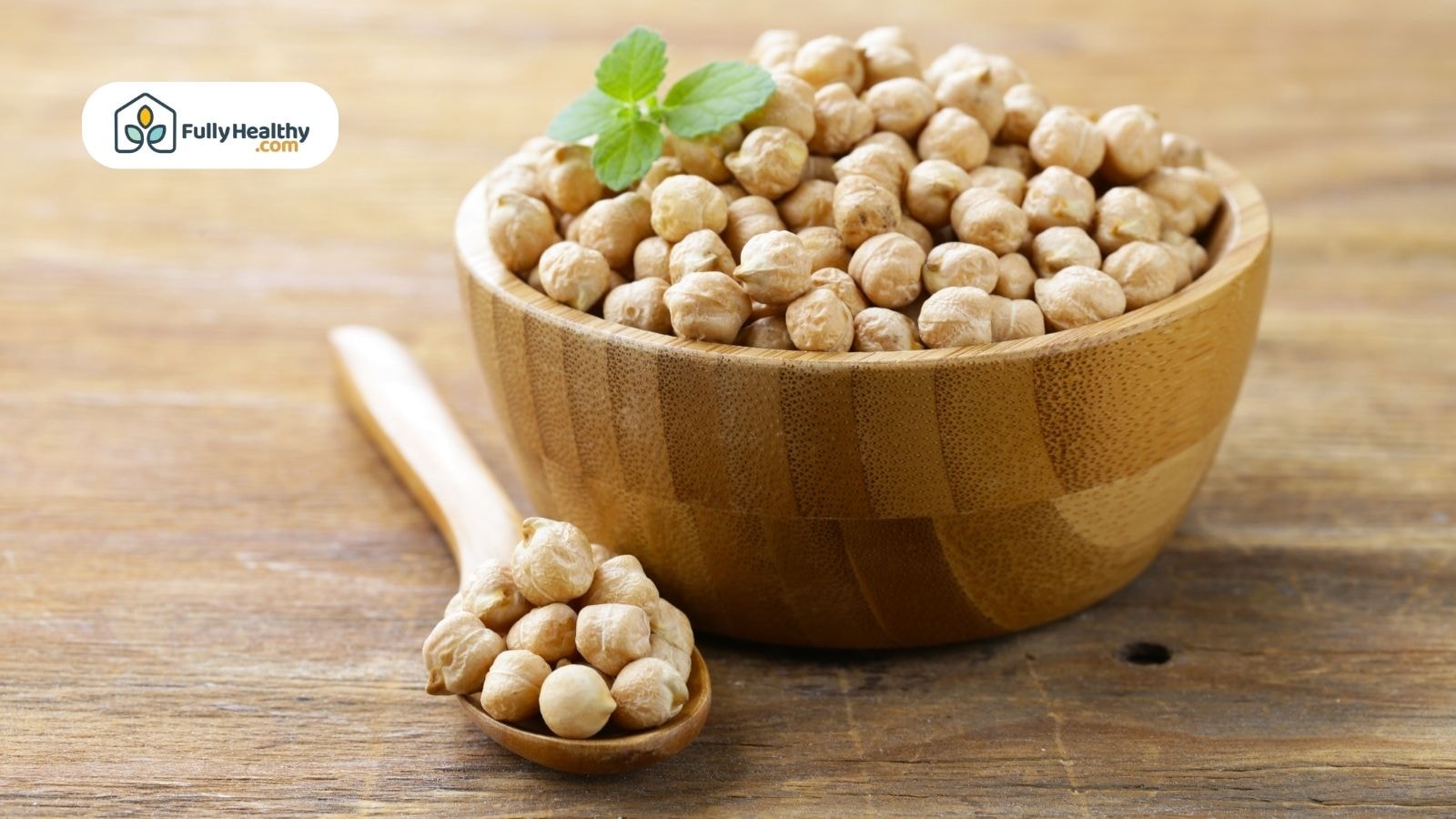 Wooden bowl filled with dried chickpeas and spoon
